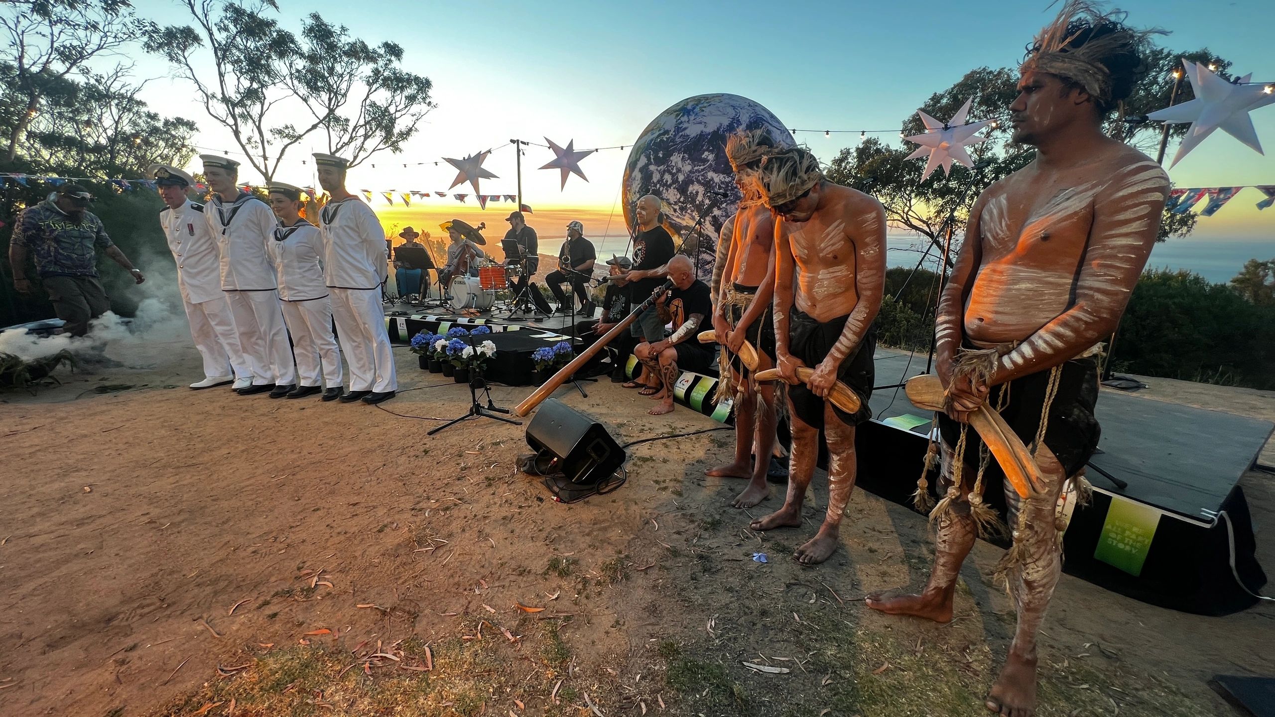 Coastal ceremony at sunset with cultural performance overlooking Port Phillip Bay