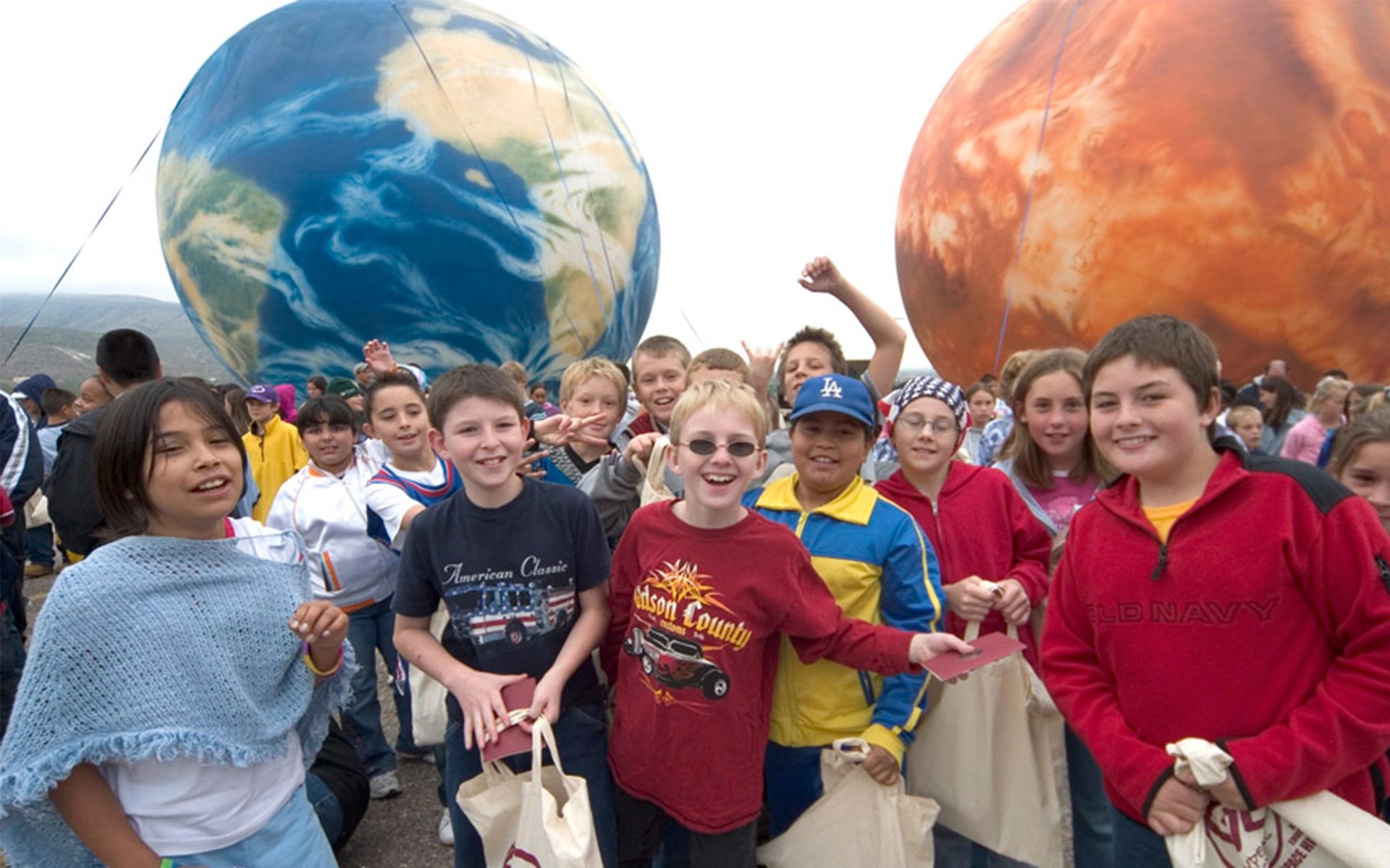 Children with Earth and Mars planetary spheres at The Planets exhibition