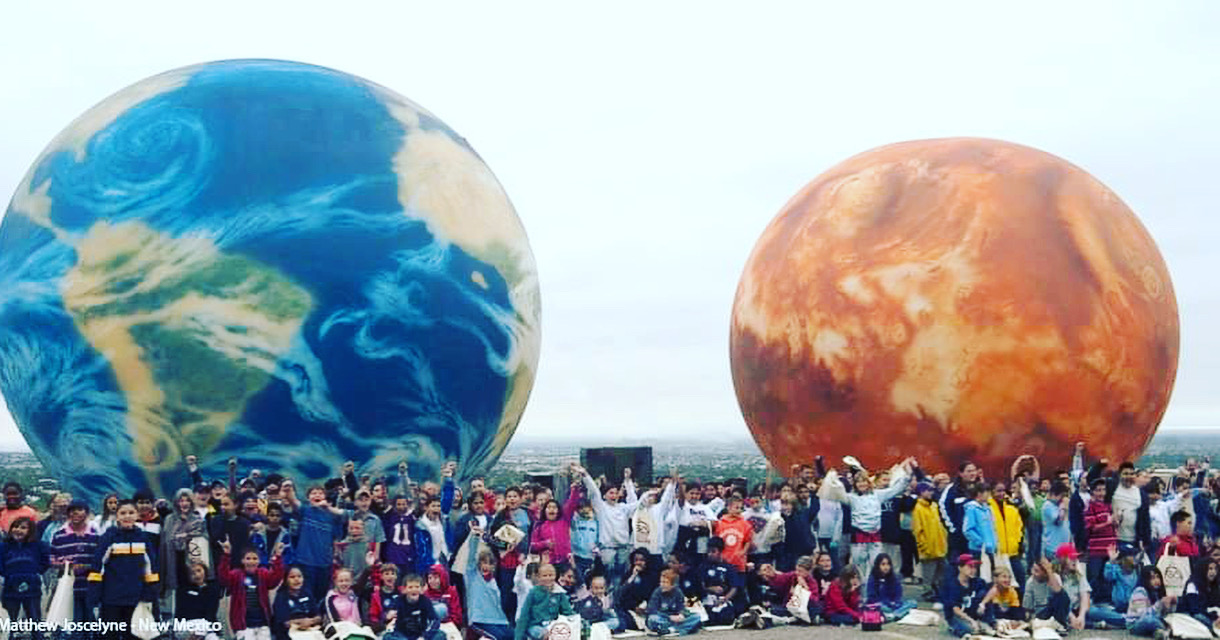 Community gathered with Earth and Mars planetary spheres in New Mexico