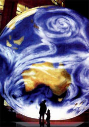 Visitors looking up at a large illuminated Earth globe